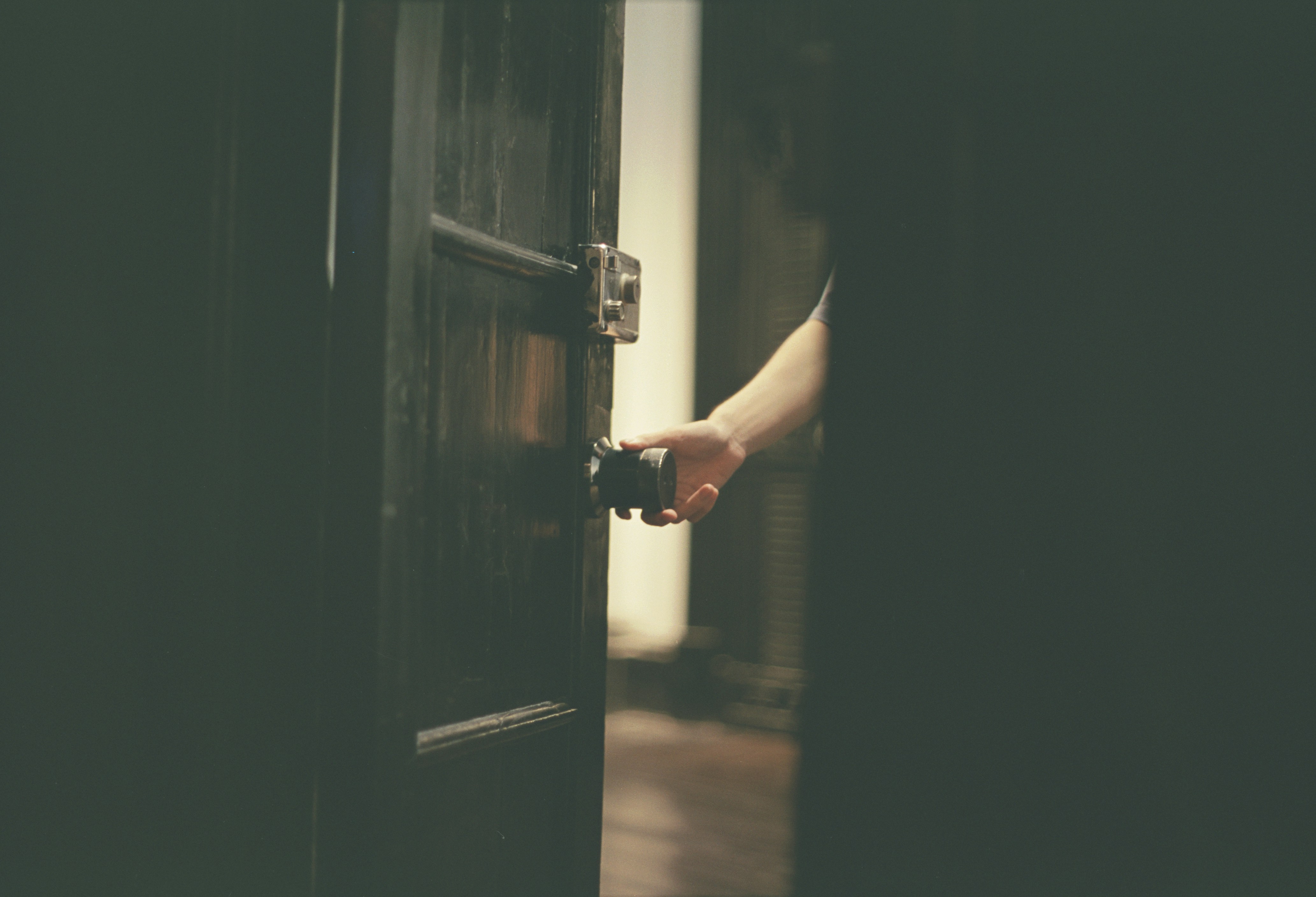 A person opening a door with their hand